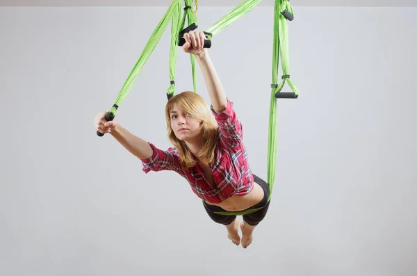 La chica realiza ejercicios en una hamaca para yoga —  Fotos de Stock