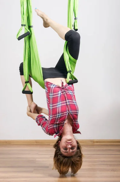 Kız bir hamakta yoga egzersizleri gerçekleştirir