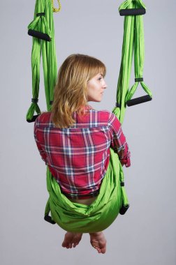 Kız bir hamak ile çalışmaları için yoga gerçekleştirir.