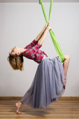 Kız bir hamak ile çalışmaları için yoga gerçekleştirir.