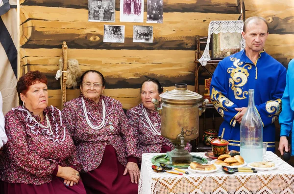 Kadınlar ve erkekler bir rustik iç Ulusal giysiler içinde