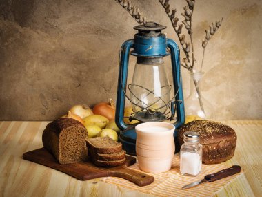 Pot süt, çavdar ekmeği, gazyağı fener ve sebze masanın üzerinde. Rustik tarzı natürmort