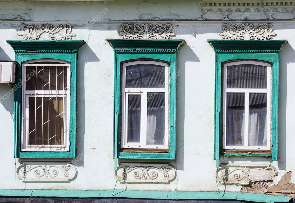 Three windows. Fragment of the facade of the old building. The picture was taken in Russia, in the city of Orenburg. 04/07/2018