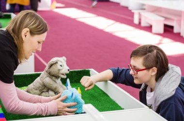 Kız bir alışveriş merkezinde bir sergisinde otomatik oyuncaklar ile iletişim kurar. Resmin şehir Orenburg, robotlar 