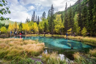 Mountain Altai Altai, Russia - September, 13, 2019: Tourists on the shore of Geyser Lake