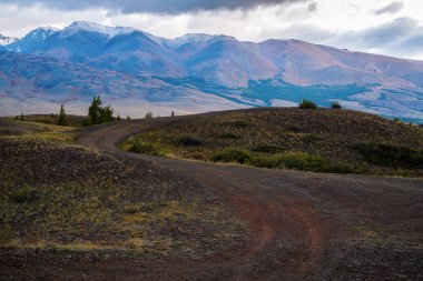 Chui Vadisi 'nde şafak vakti, yamaçta bir tarla yolu. Rusya, Altai Dağı
