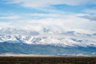 Kuzey Chuysky sırtı şafakta bulutlarda. Rusya, Altai Dağı