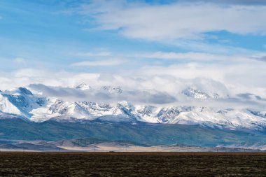 Kuzey Chuysky sırtı şafakta bulutlarda. Rusya, Altai Dağı