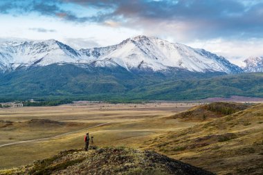 Kurai bozkırındaki bir tepede seyahat fotoğrafçısı, Kuzey Chuysky sırtı manzaralı. Kosh-Agachsky Bölgesi, Altai Cumhuriyeti, Rusya
