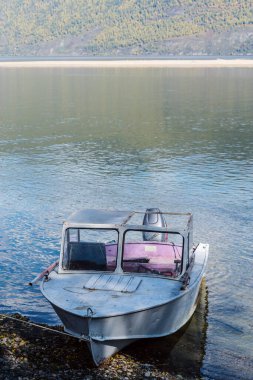 Dağ gölünün kıyısına demirlemiş bir motorlu tekne. Rusya, Altai Cumhuriyeti, Ulagansky Bölgesi, Teletskoye Gölü, Kirsay Burnu
