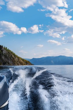 Dağ gölünde yelken açan bir motorlu teknenin kıç tarafı. Düş! Rusya, Altai Cumhuriyeti, Teletskoye Gölü