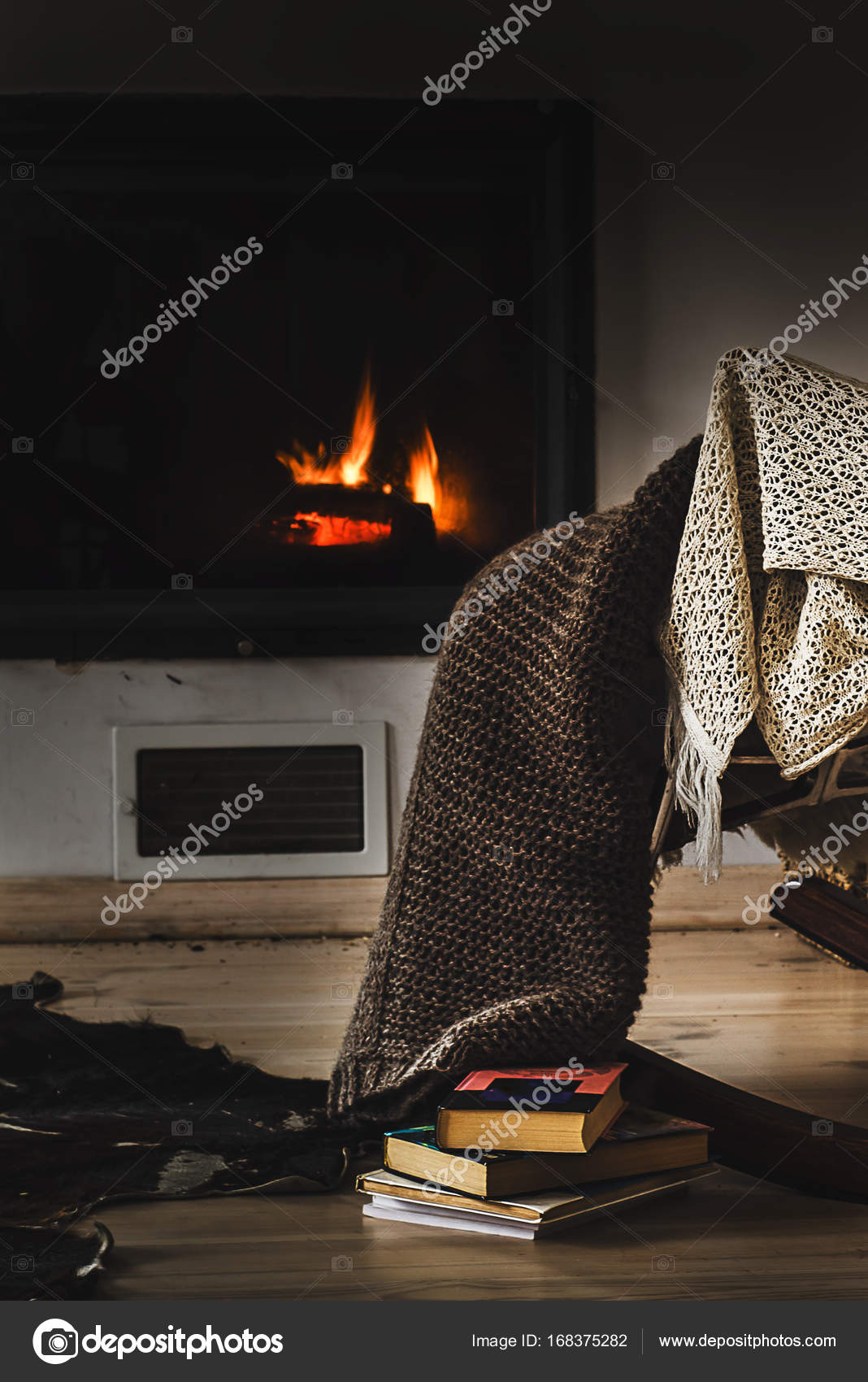 Rocking chair with knit rug, books and cup of tea or coffee before