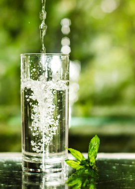 Serin temiz su buz ve nane ile. Splash cam. Sağlıklı yaşam konsepti