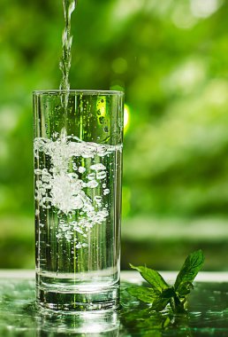 Serin temiz su buz ve nane ile. Splash cam. Sağlıklı yaşam konsepti