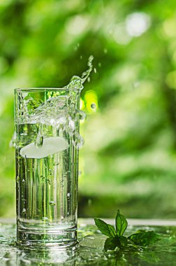 Serin temiz su buz ve nane ile. Splash cam. Sağlıklı yaşam konsepti