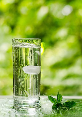 Serin temiz su buz ve nane ile. Splash cam. Sağlıklı yaşam konsepti