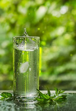 Serin temiz su buz ve nane ile. Splash cam. Sağlıklı yaşam konsepti