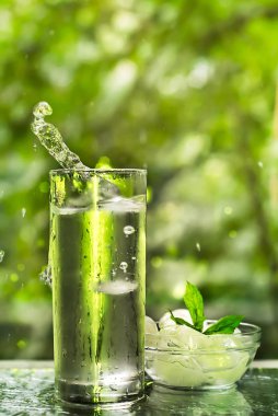 Serin temiz su buz ve nane ile. Splash cam. Sağlıklı yaşam konsepti