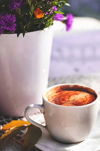 Fincan espresso kahve ve çiçekler buket tığ işi dantel masa örtüsü ile masada