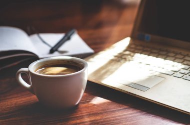 Dizüstü bilgisayar, fincan kahve ve not defteri. İş veya serbest coffeebreak