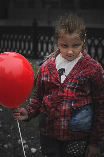 Petite fille avec ballon rouge costumé comme un zombie à Halloween — Photo