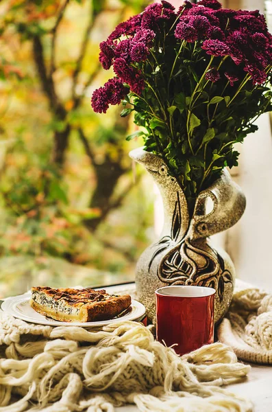 Sonbahar natürmort çiçek vazo, dilim peynir, çay veya kahve ve örgü kilim