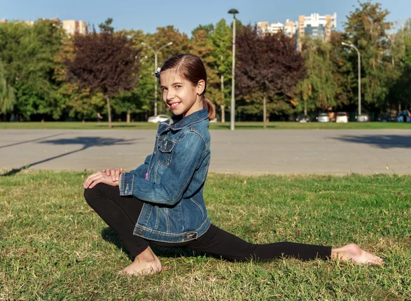 若い女の子は、草の上の体操に取り組んでいます。健康的な李 — ストック写真