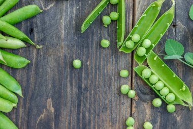 Bezelye ve pods bezelye karanlık bir arka plan üzerinde. Sağlıklı beslenme kavramı.