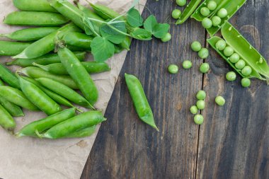 Bezelye ve pods bezelye karanlık bir arka plan üzerinde. Sağlıklı beslenme kavramı.