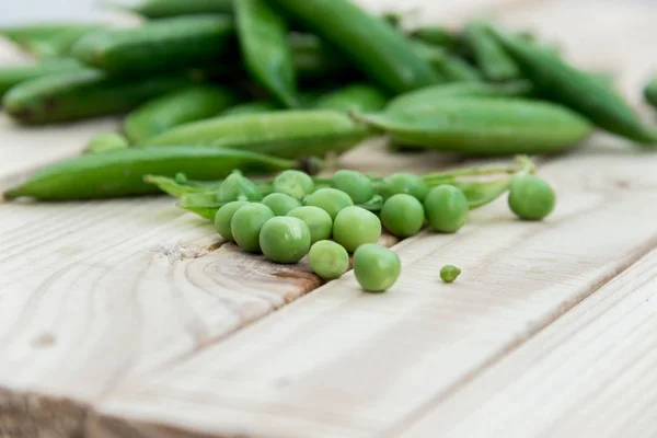 Doperwten en peulen van erwten op een donkere achtergrond. Begrip van gezond eten. — Stockfoto