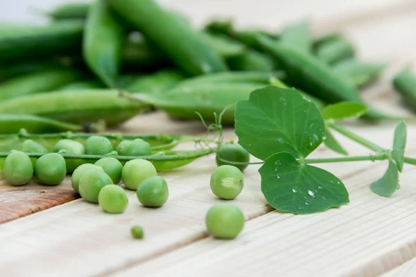 Doperwten en peulen van erwten op een donkere achtergrond. Begrip van gezond eten. — Stockfoto