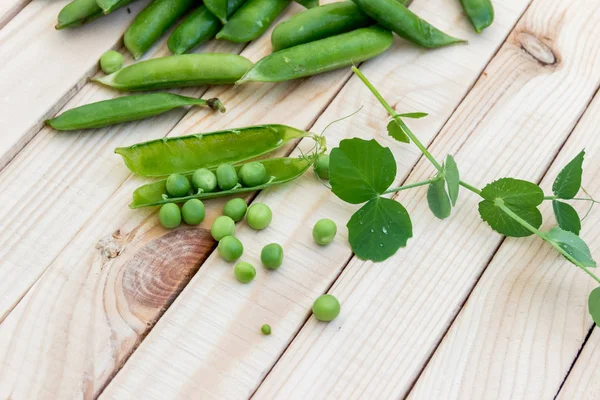 Doperwten en peulen van erwten op een donkere achtergrond. Begrip van gezond eten. — Stockfoto