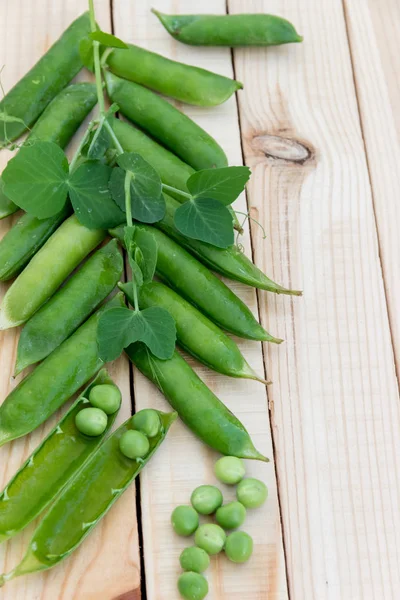 Guisantes y vainas de guisantes sobre un fondo oscuro. Concepto de alimentación saludable . — Foto de Stock