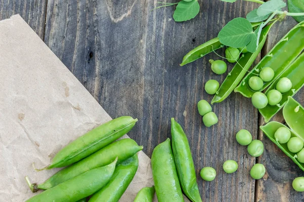 Guisantes y vainas de guisantes sobre un fondo oscuro. Concepto de alimentación saludable . — Foto de Stock