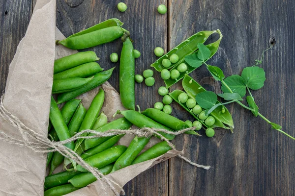 Guisantes y vainas de guisantes sobre un fondo oscuro. Concepto de alimentación saludable . — Foto de Stock