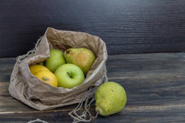 Taze meyve karanlık bir arka plan üzerinde bir zanaat çanta. Sağlıklı beslenme kavramı.