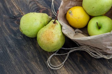 Taze meyve karanlık bir arka plan üzerinde bir zanaat çanta. Sağlıklı beslenme kavramı.