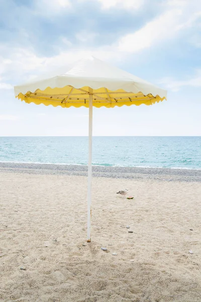 Gelber Sonnenschirm am Sommerstrand — Stockfoto
