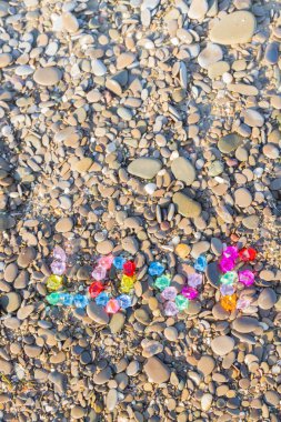 Renkli cam taş deniz kayaların üzerinde yazıt sevgisi