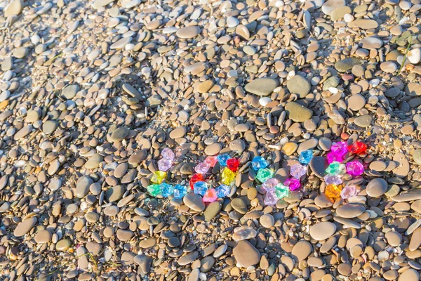 Renkli cam taş deniz kayaların üzerinde yazıt sevgisi — Stok fotoğraf