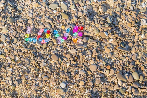 The inscription love of colored glass stones on sea rocks — Stock Photo, Image