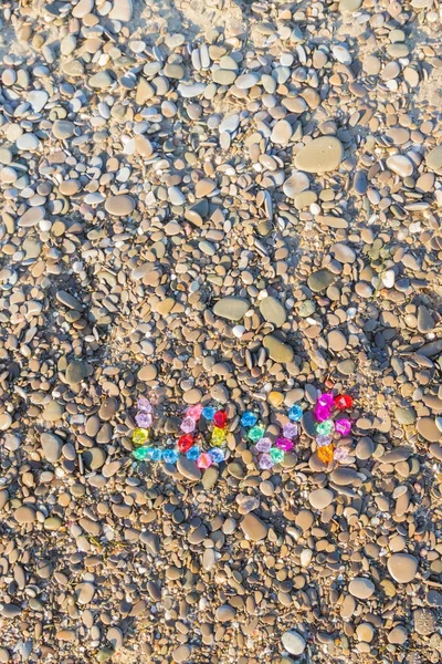 Renkli cam taş deniz kayaların üzerinde yazıt sevgisi