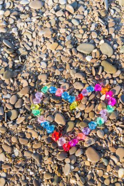 Cam çakıl deniz kıyısında parlak renkli kalp