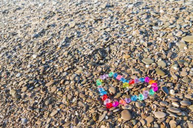 Cam çakıl deniz kıyısında parlak renkli kalp