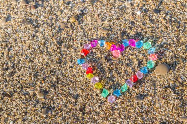 Cam çakıl deniz kıyısında parlak renkli kalp