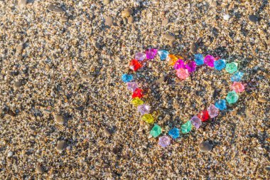 Cam çakıl deniz kıyısında parlak renkli kalp