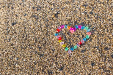 Cam çakıl deniz kıyısında parlak renkli kalp