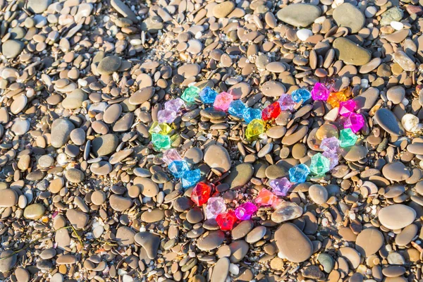 Cam çakıl deniz kıyısında parlak renkli kalp