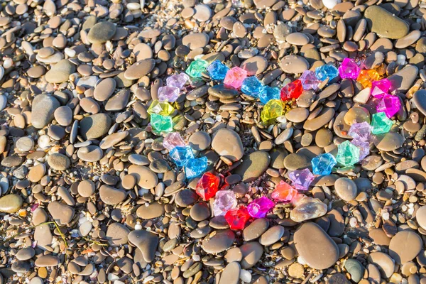 Cam çakıl deniz kıyısında parlak renkli kalp