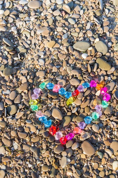 Cam çakıl deniz kıyısında parlak renkli kalp